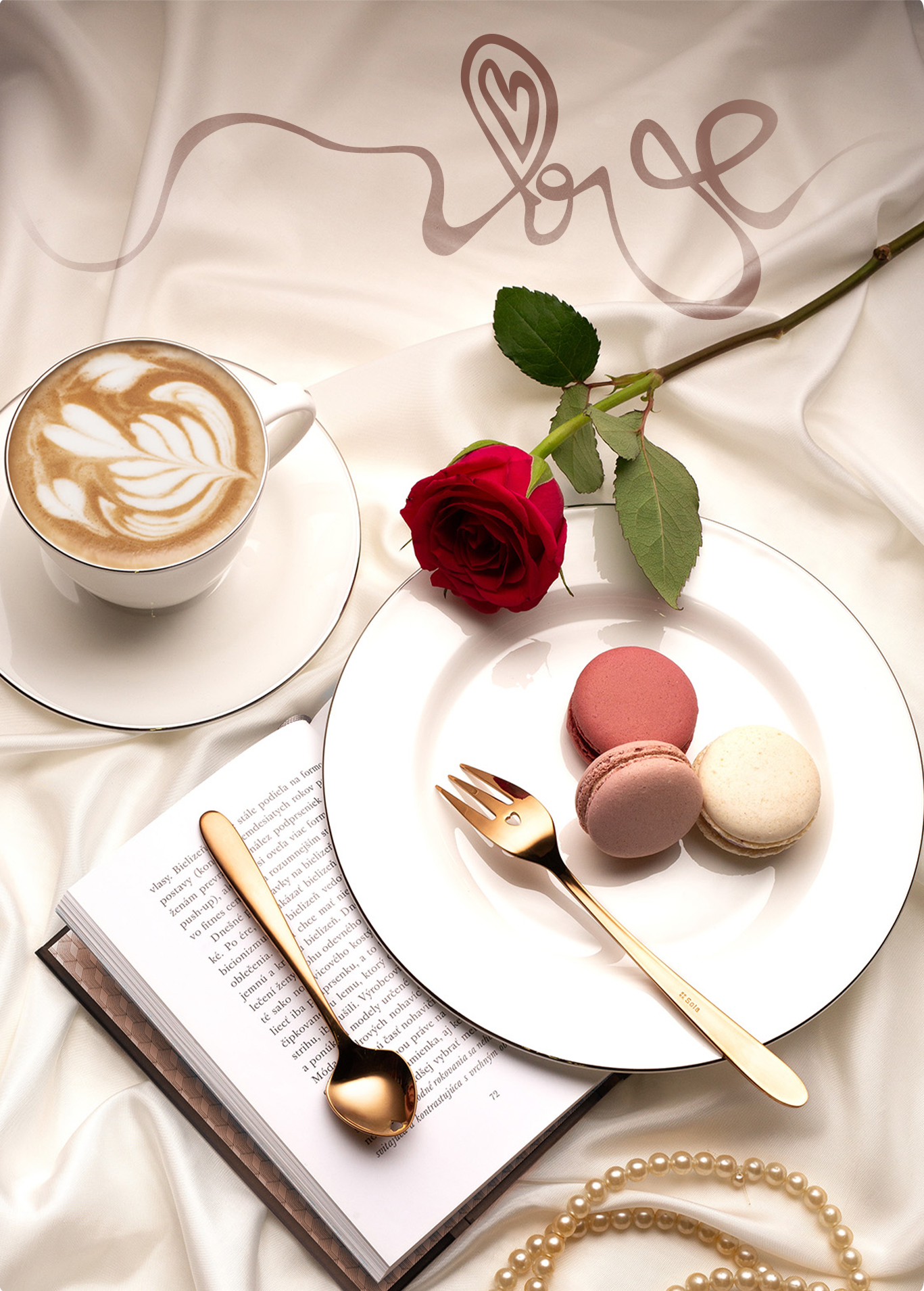 Eine Tasse Kaffee, eine rote Rose, Macarons, ein Buch und goldenes Besteck liegen auf einem weißen Satinstoff 